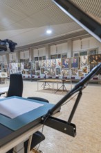 Exhibition gallery with artworks, stands and tables in the interior, historical art exhibition in