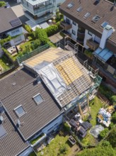Aerial view of a house with roof under construction in suburban location, roof renovation, house