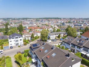 Bird's eye view of a residential neighbourhood with tiled roofs against an urban backdrop, roof
