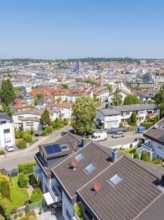 View of a residential area with tiled roofs and neighbouring urban skyline, roof renovation, house