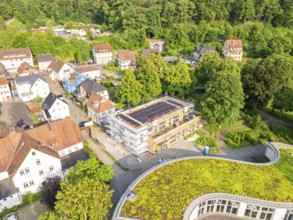 View of a residential area with a building site in the centre and green areas on some roofs,