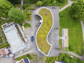 Aerial view of a building with a curved green roof and surrounding car park, Hirsau, Calw, Germany