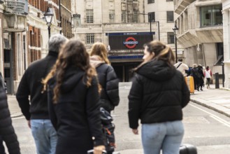 Tourists walking on a london street towards st. Paul's tube station, a major transportation hub in
