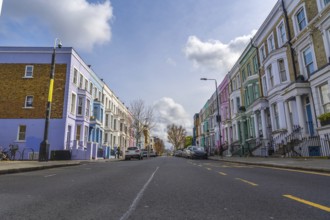 Vibrant pastel colored houses create a picturesque scene along a charming street in notting hill,