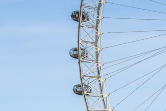 Glass capsules slowly rotating on the london eye ferris wheel against a clear blue sky, offering