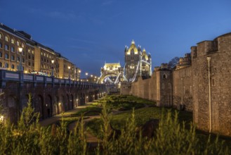 Tower bridge and the tower of london stand majestically illuminated against the twilight sky,