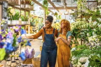 Two young women working together in a garden center, discussing vibrant plants and creative flower