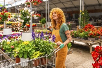 Woman pushing a shopping cart filled with vibrant flowers and lush plants while navigating through