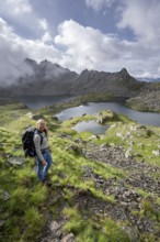 Mountaineer on hiking trail, view of mountain landscape with mountain lakes Wangenitzsee and