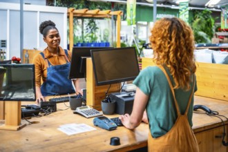 Garden center cashier processing a customer's purchase, creating a positive and efficient shopping