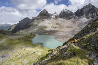 Mountaineer on hiking trail, view of turquoise-blue mountain lake Großer Gradensee, behind summit