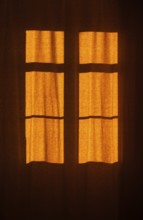 Interior view of a window with red curtain