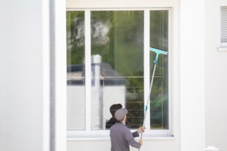 Building cleaner cleans the windows of a new residential building
