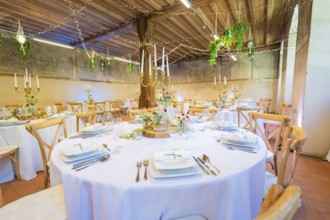 Elegant wedding decor in a rustic room with fairy lights and green accents, event and wedding