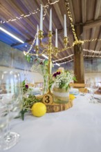 Detailed table decoration with candlestick and licence plate, surrounded by fresh flowers, event