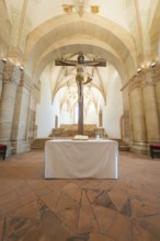 Altar with crucifix in a sacred room with stone arches, event and wedding location Lorch Monastery,