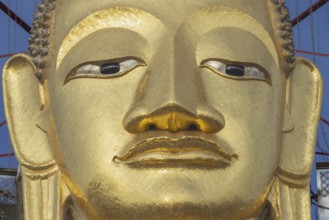 Face of a 32 metre high standing Buddha decorated with glass mosaics and 24-carat gold, Luang Pho