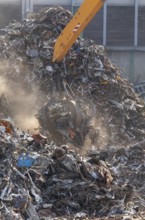 Hydraulic crane lifts scrap metal at the scrap yard