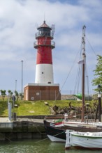 Lighthouse, sailing boat in the foreground, Büsum, North Sea, Schleswig-Holstein, Germany