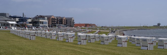 Beach chairs on the green beach, building on the promenade, Büsum, North Sea, Schleswig-Holstein,