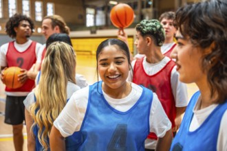 Happy basketball players chatting and smiling during a game break in a gymnasium, enjoying