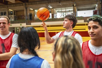 Young basketball player spinning ball on finger, surrounded by teammates in gym, showcasing skill