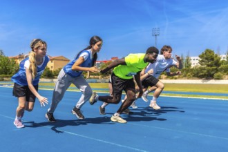Young athletes sprinting energetically on a vibrant blue track under the bright sun, showcasing