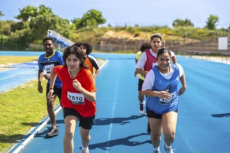 Determined young athletes running on a blue track, striving for victory during a track and field