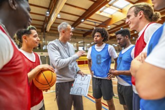 Basketball coach discussing game strategy with team members while using a clipboard on the