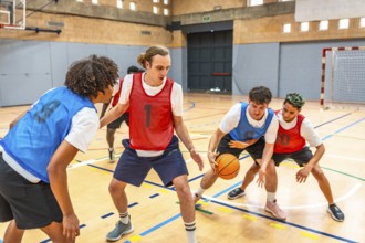 Young basketball players practicing in a gym, focusing on defense and attack strategies during a