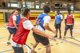 Young basketball players practicing in a gym, focusing on teamwork and skill development during a
