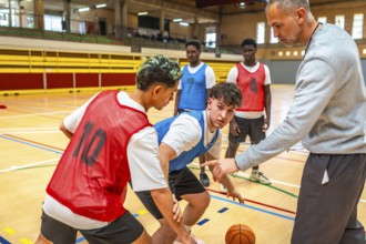 Basketball coach guiding young players, explaining tactics and positions on the court during