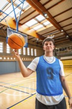 Young basketball player spinning a ball on his finger in a gym, showcasing his skills and passion