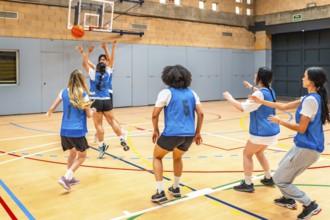 Group of young female athletes competing in a basketball match, showcasing their skills and