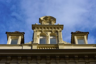 Decorative façade of a historic building with windows and baroque details under a blue sky,