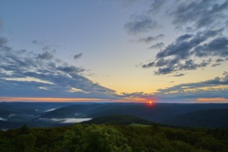 Sunrise over a forest landscape with vivid sky and clouds, warm colours of the morning,