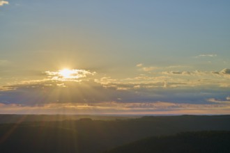Sunrise over a calm landscape with clouds and rays of light, Katzenbuckel, Waldbrunn,
