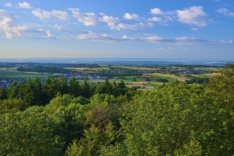 View over green trees and fields with clear sky and scattered clouds, Katzenbuckel, Waldbrunn,