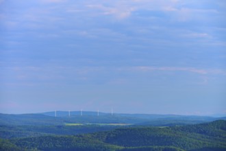 Hilly landscape with clouds, wind turbines on the horizon under a blue sky, Katzenbuckel,