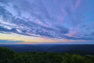 Purple and pink clouds fill the night sky over a forest landscape, twilight, Katzenbuckel,