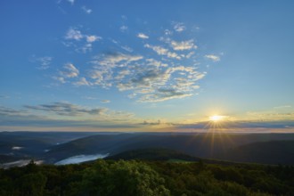 Morning sun over a vast forest landscape, clear sky with some clouds, Katzenbuckel, Waldbrunn,
