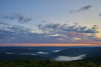 Wide mountain landscape at sunrise, sky covered by clouds in soft colours, Katzenbuckel, Waldbrunn,