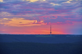 Dramatic sunrise on the horizon with a transmission mast, transmitter Reisenbach, as silhouette,