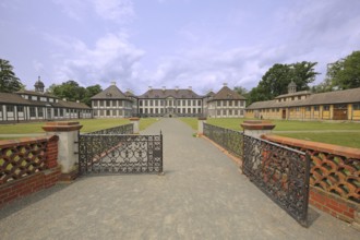 Entrance with decorated metal door to the baroque castle, wrought ironwork, decorations, garden