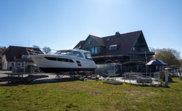 Motor yacht on a slag heap, Neuensiener See jetty in Seedorf, Rügen, Mecklenburg-Western Pomerania,