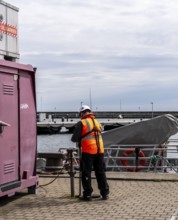 Worker with safety waistcoat in the city harbour of Sassnitz, Rügen, Mecklenburg-Vorpommern,
