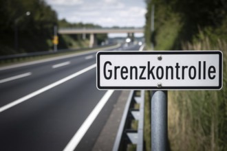 Road sign saying 'Grenzkontrolle' (border control) on side of street. Generative AI, AI generated