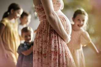 Woman with pregnant belly with happy children in blurry background, AI generated