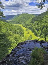 View from a hill onto a green valley (corn valley) with meadows, surrounded by wooded hills, Bad