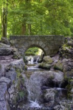 An old, small stone bridge over the Brühlbach, wild and romantic stream and source of the Urach